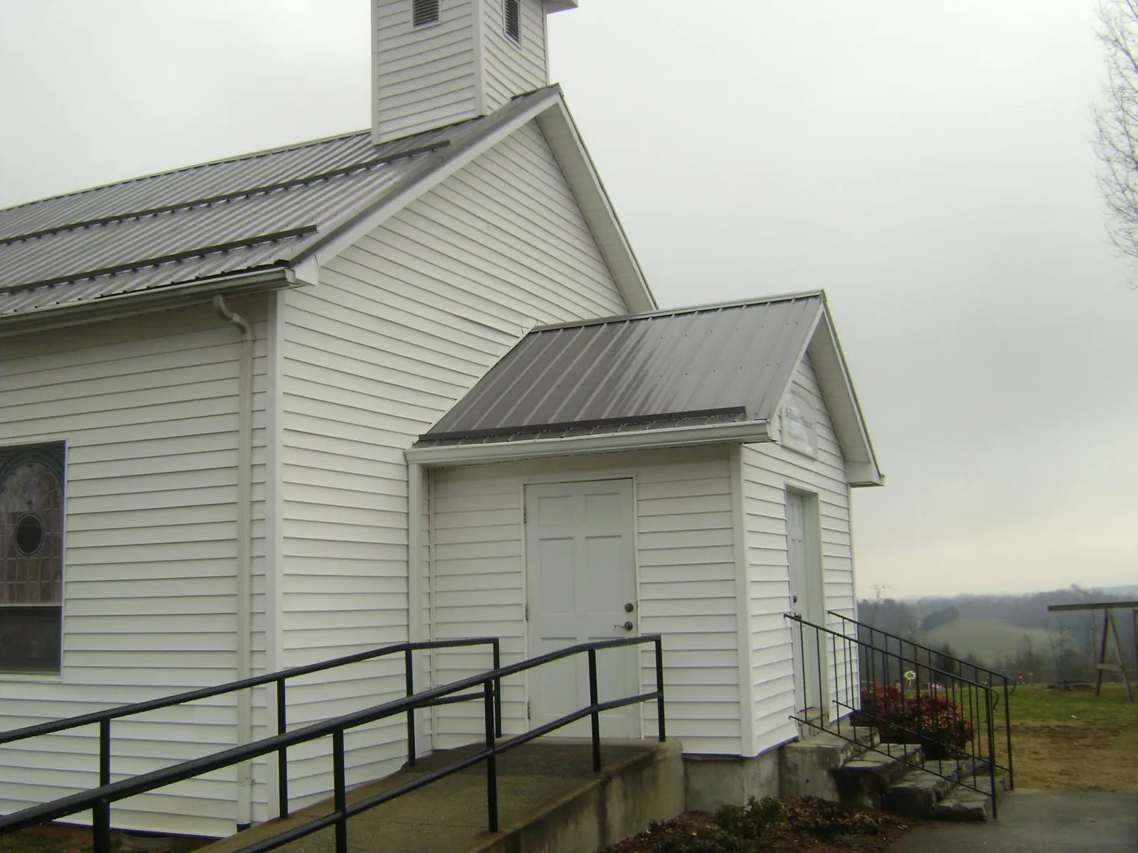 Gray metal roof on a white clapboard church with a steeple in Hereford